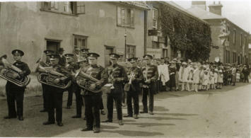 New Buckenham Band on parade.  Note George and Dragon carving on corner of pub